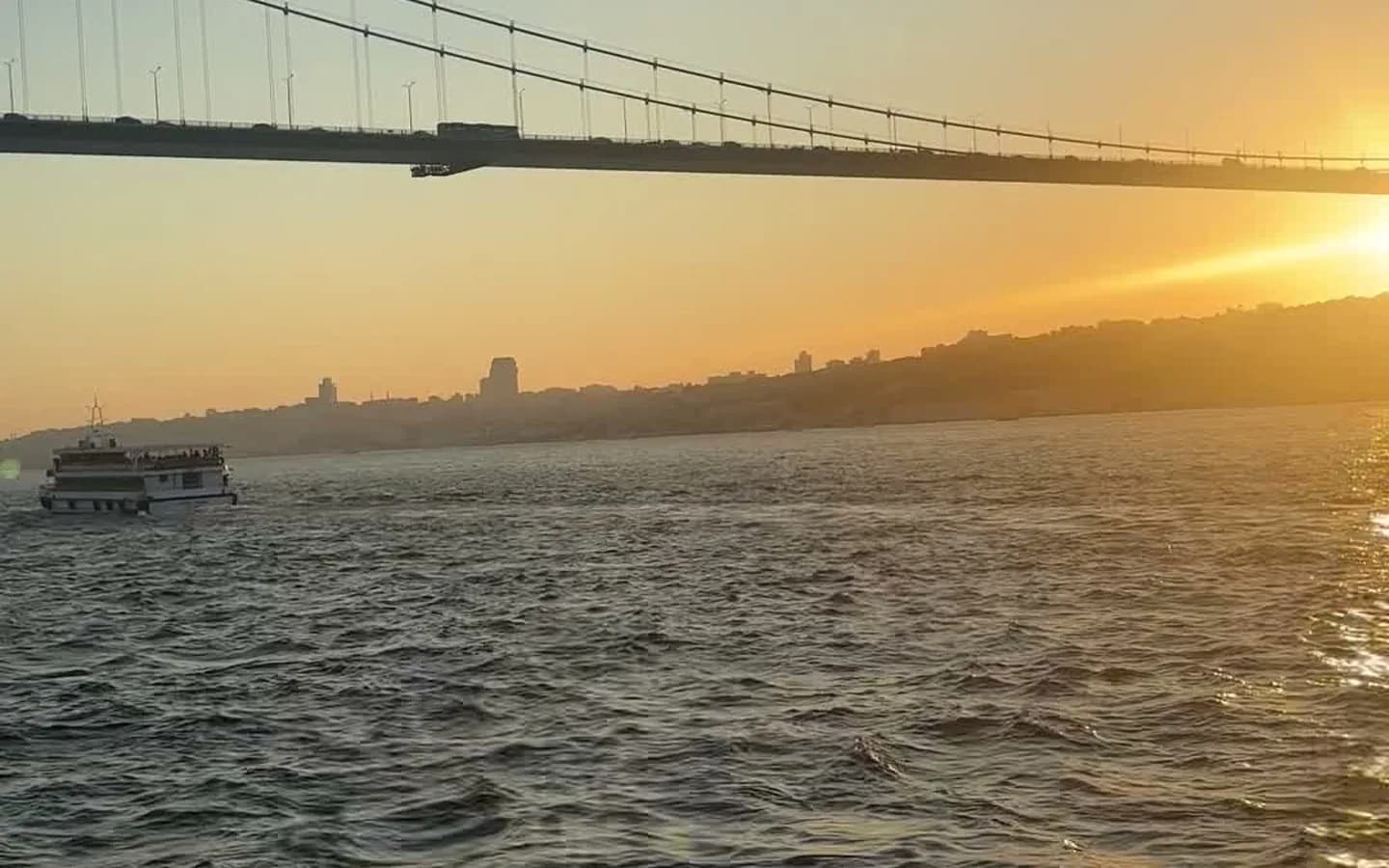 Romantic couple on a private yacht at sunset on the Bosphorus strait with Istanbul palaces and the Maiden's Tower in the background