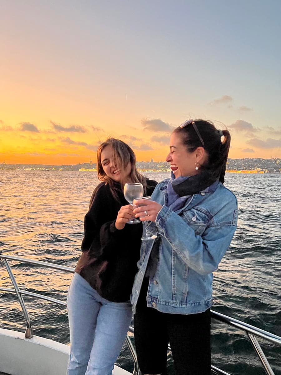Deux femmes discutent sur le pont d'un yacht au coucher du soleil