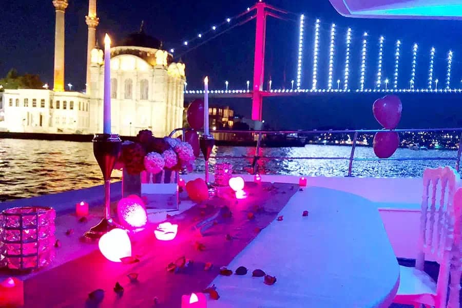 Романтический сюрприз на Босфоре, выстроенный вокруг главного момента. — a candlelit table at night with a lit mosque and bridge behind