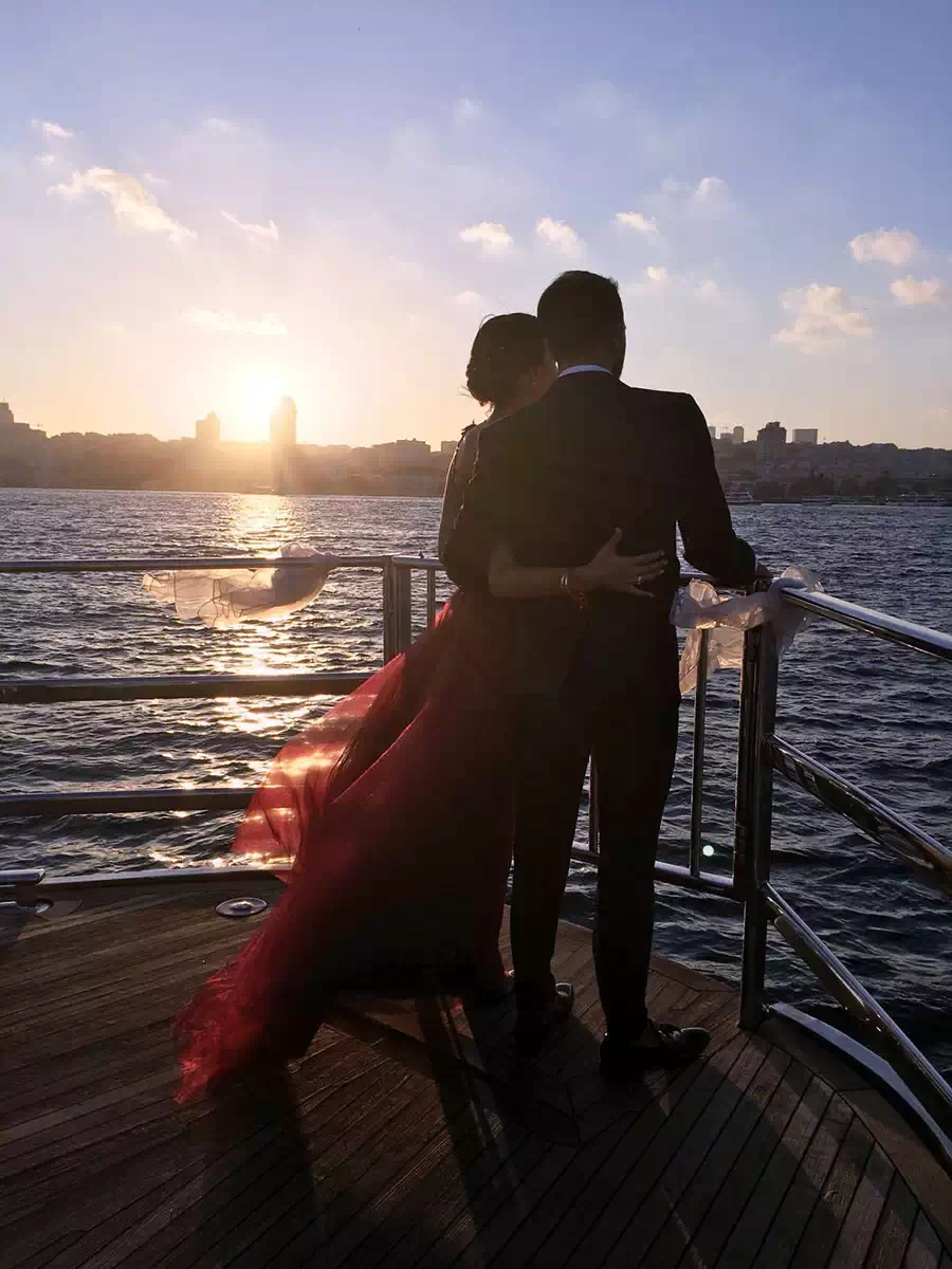 Романтический сюрприз на Босфоре, выстроенный вокруг главного момента. — a couple embracing at the rail at sunset